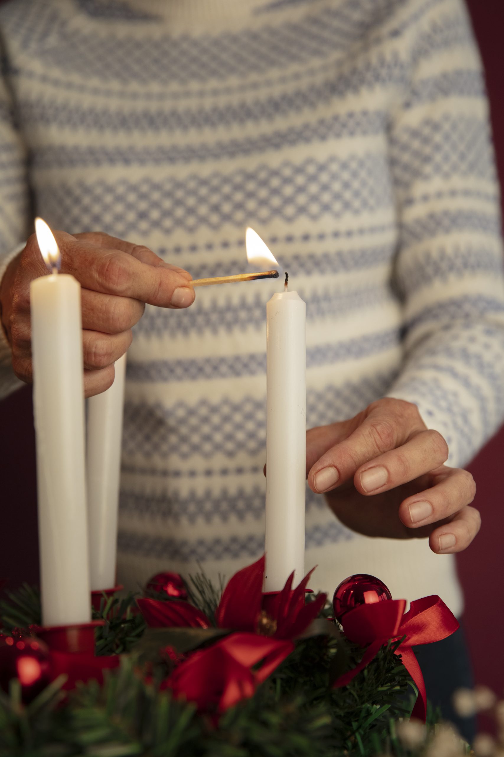 woman-lighting-wreath-candle-fire